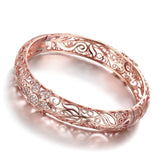 Elegant rose gold bracelet featuring intricate filigree flower design with sparkling cubic zirconia accents.
